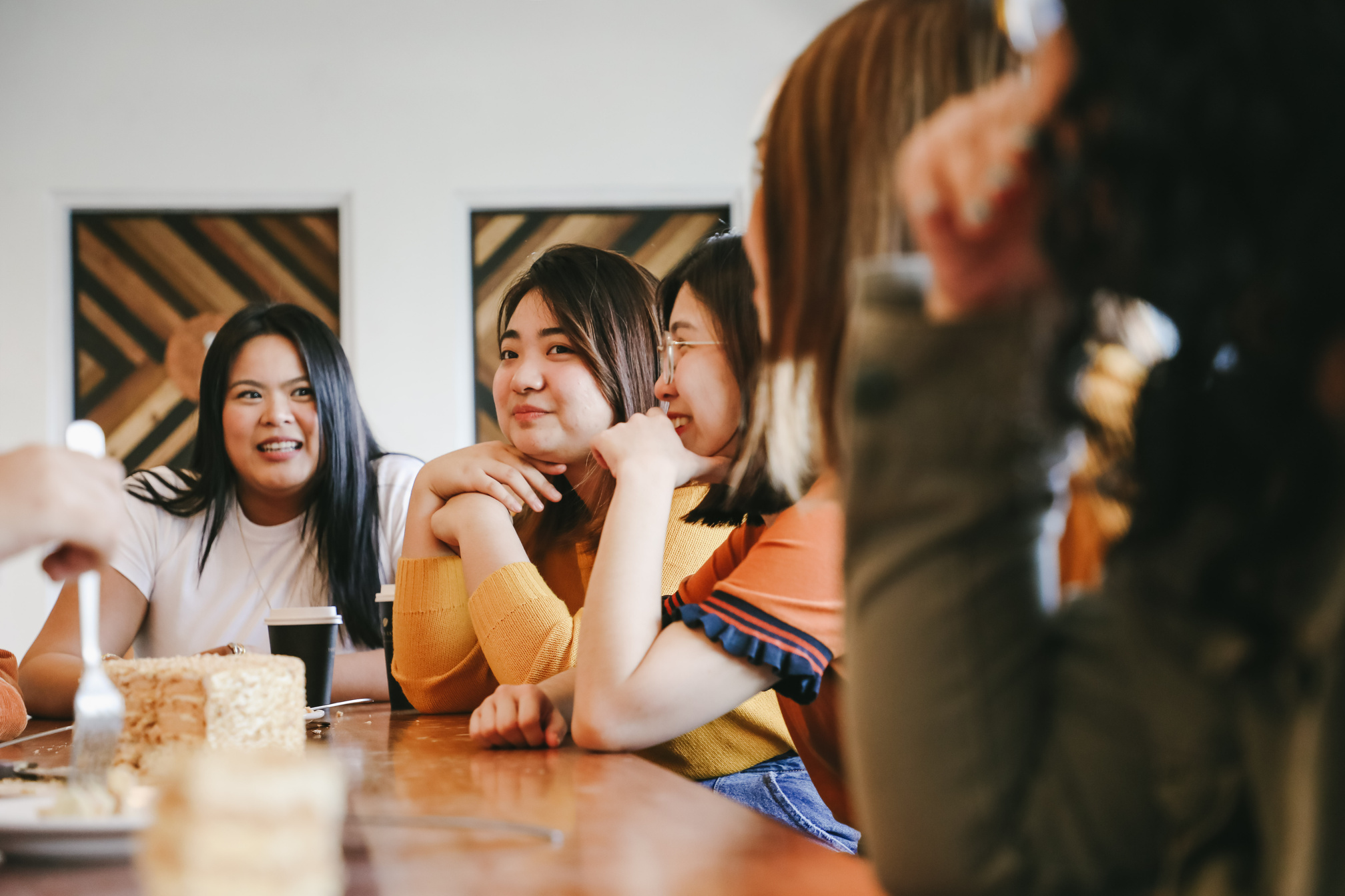 Group of women having cake and coffee in the office